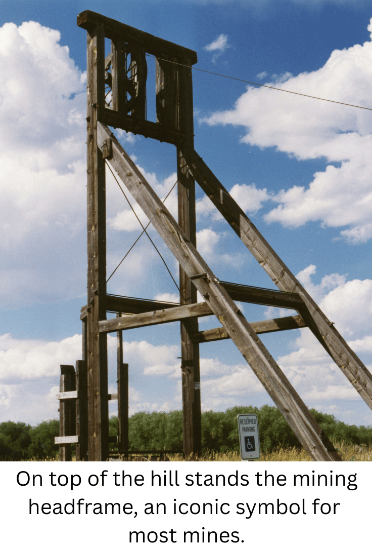 On top of the hill stands the mining headframe, an iconic symbol for most mines.