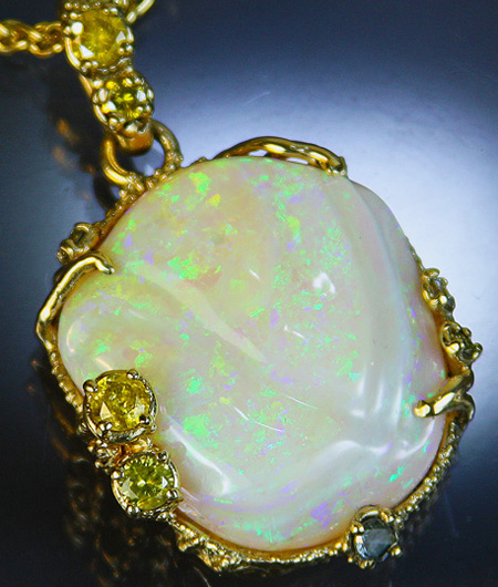 Fine Brazilian opal cut and carved by Dan Baker, set in 14kt gold pendant with yellow diamonds