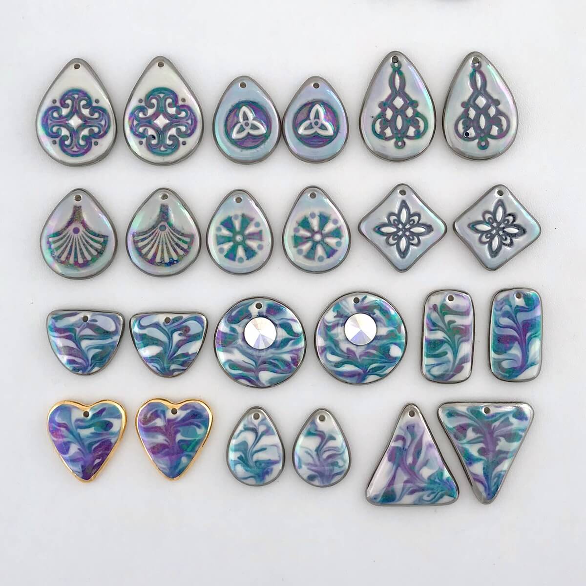 Earring components in shades of blue. The iridescent overglaze creates flashes of green & purple on the surface.