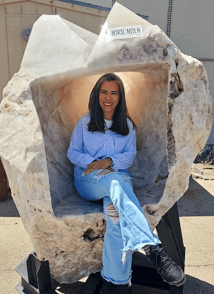 A woman sitting in a large crystal seat.