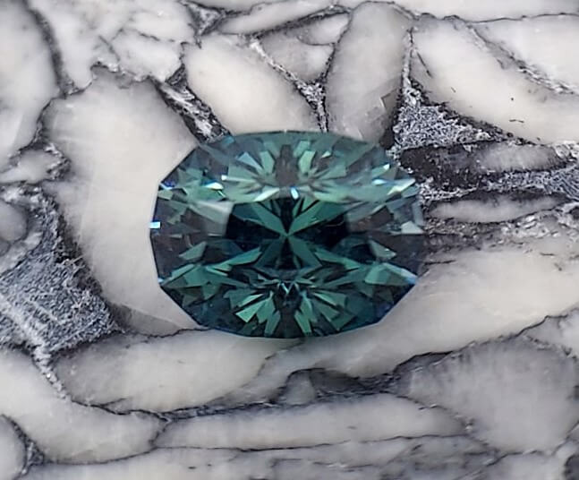 A dark green faceted Montana Sapphire.